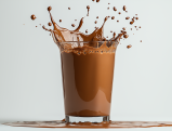 Glass of chocolate protein shake with a dramatic splash and droplets